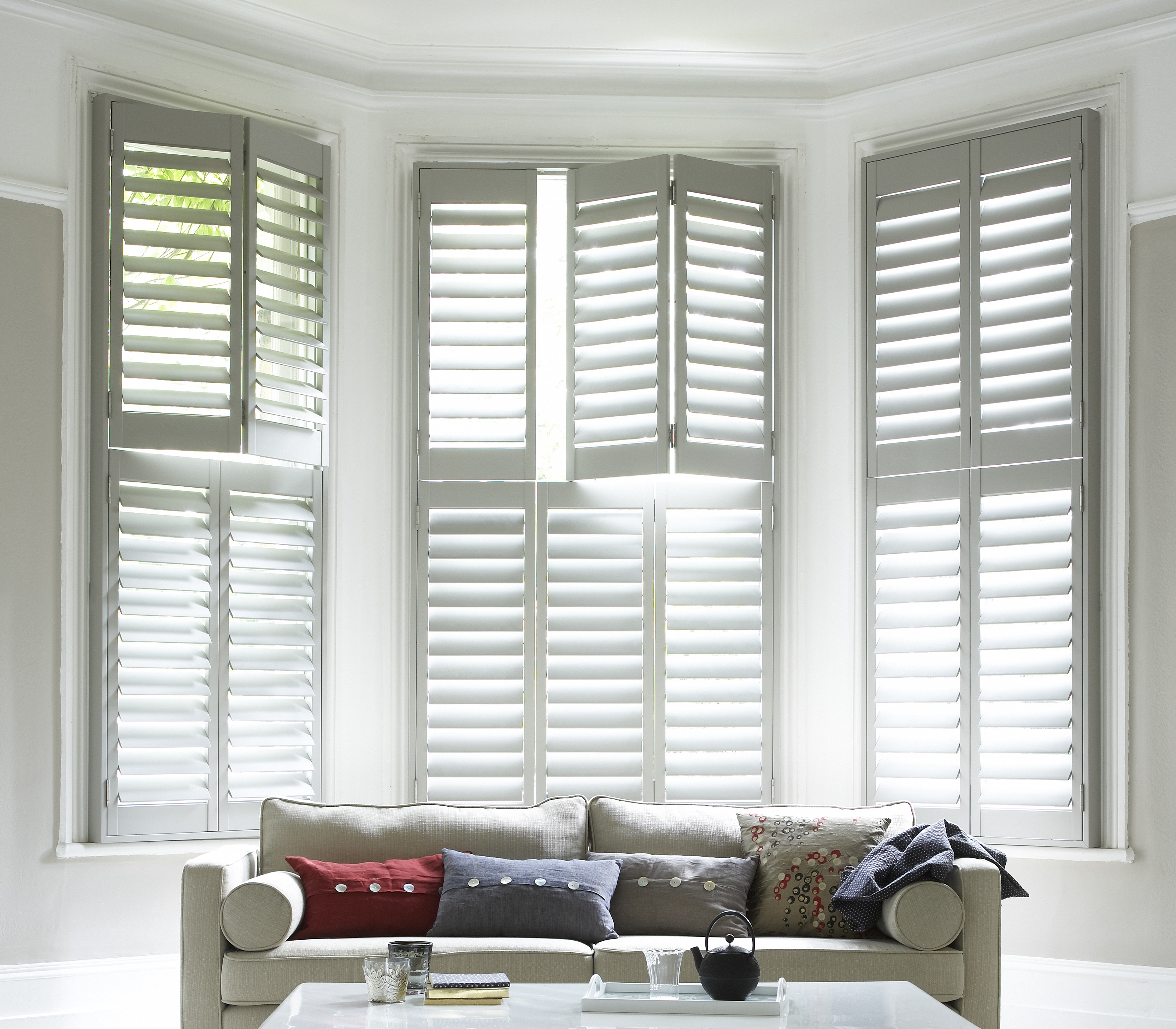 SureFix Shutters Waterlooville -Paulownia, Tier on Tier, Grey White, Lounge, Straight on Paulownia plantation-style window shutters in white in a living room